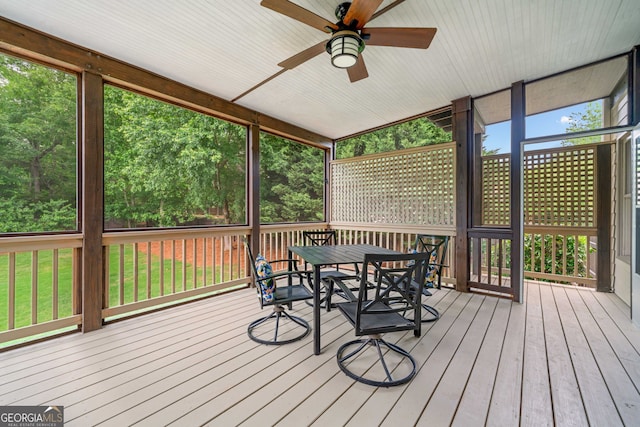 sunroom featuring outdoor dining area and ceiling fan