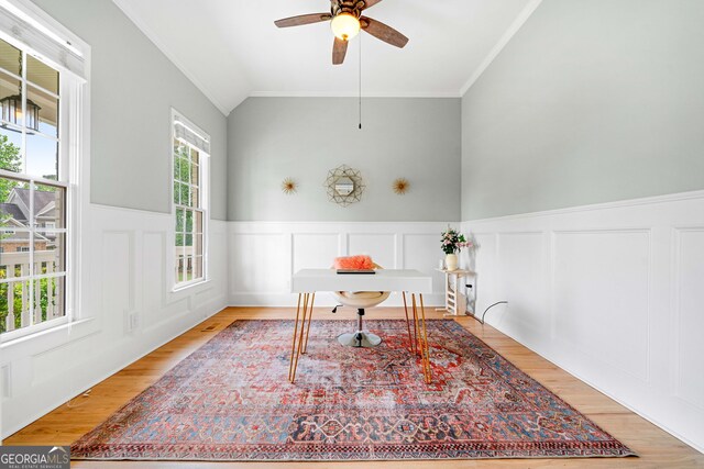 office featuring ceiling fan, wainscoting, light wood-style flooring, vaulted ceiling, and ornamental molding