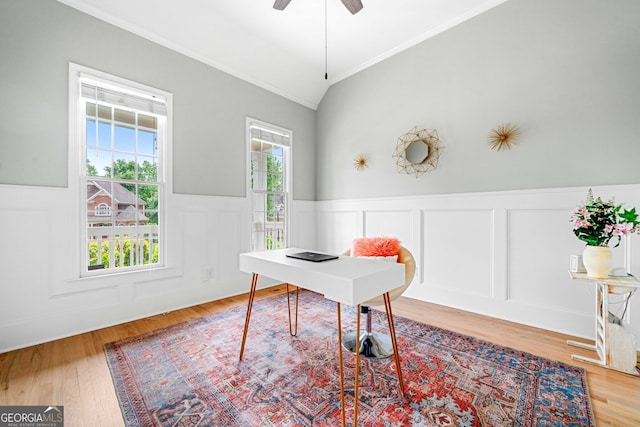 office area featuring ornamental molding, wainscoting, wood finished floors, and vaulted ceiling