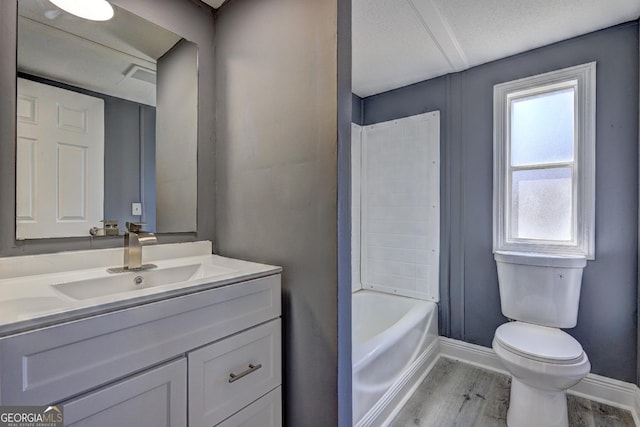 bathroom with baseboards, wood finished floors, toilet, and vanity