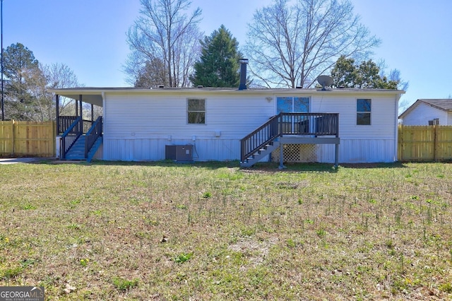 rear view of property featuring stairs, a lawn, and fence