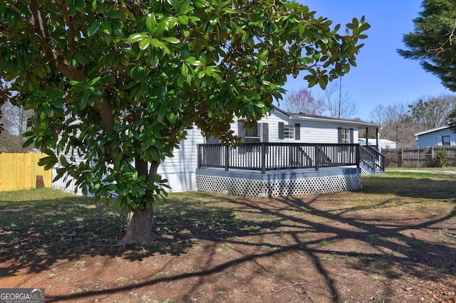 view of front of property featuring fence and a wooden deck