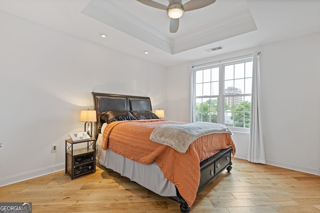 bedroom featuring visible vents, crown molding, recessed lighting, a raised ceiling, and light wood-style flooring