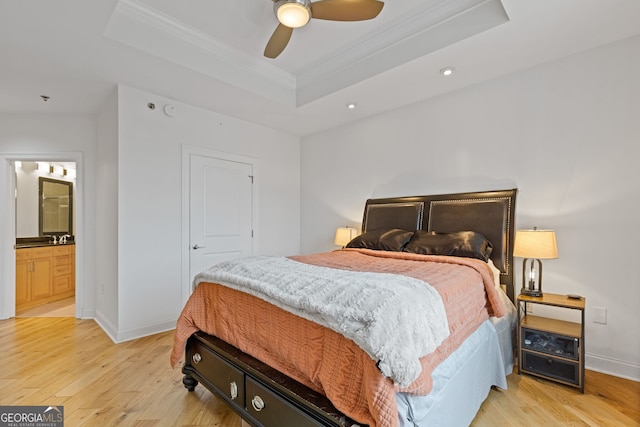 bedroom with crown molding, light wood finished floors, a raised ceiling, recessed lighting, and baseboards