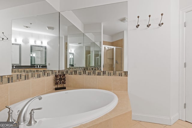 full bath with baseboards, tile patterned flooring, a bath, and a stall shower