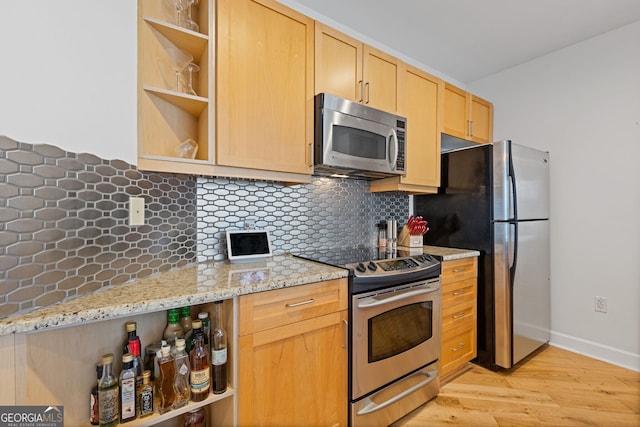 kitchen with open shelves, light brown cabinets, light stone counters, light wood-style flooring, and appliances with stainless steel finishes