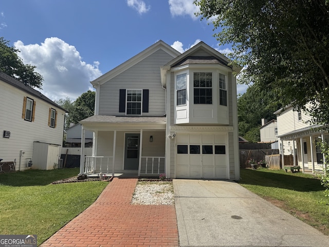 traditional home with covered porch, concrete driveway, a front yard, and a garage