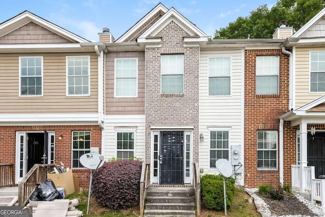 multi unit property with a chimney and brick siding