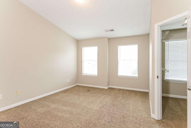 unfurnished bedroom featuring baseboards, carpet flooring, and visible vents