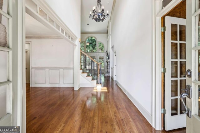 9075 Preston Ln, Suwanee, GA 30024 - foyer entrance featuring stairs, a chandelier, ornamental molding, wood finished floors, and a towering ceiling