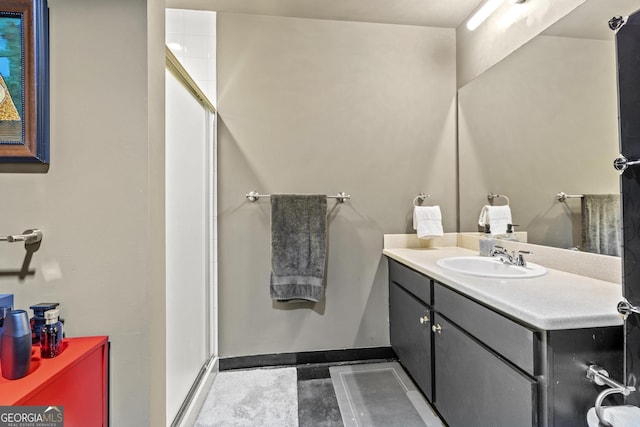 bathroom with vanity, baseboards, and a shower stall