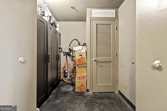 corridor with visible vents and concrete floors