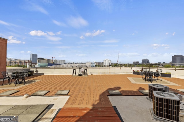 view of patio / terrace featuring central air condition unit, a city view, and outdoor dining area