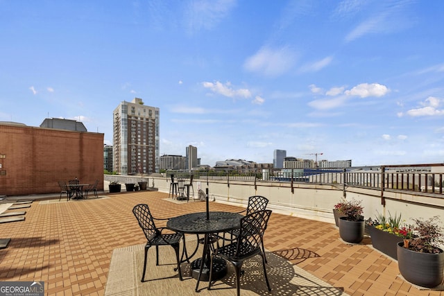 view of patio / terrace featuring a view of city and outdoor dining space