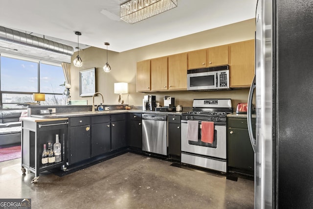 kitchen featuring a peninsula, a sink, concrete floors, decorative light fixtures, and stainless steel appliances
