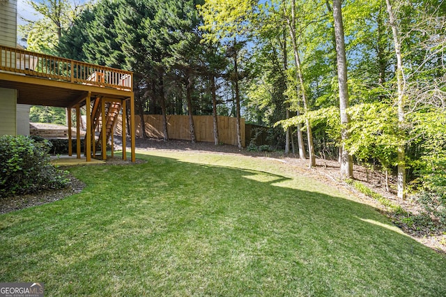 view of yard featuring fence, stairway, and a deck