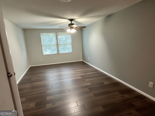 spare room featuring a textured ceiling, ceiling fan, baseboards, and dark wood-type flooring