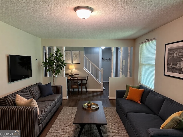 living room featuring stairs, a textured ceiling, and wood finished floors