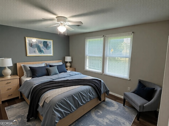 bedroom with a textured ceiling, baseboards, a ceiling fan, and wood finished floors