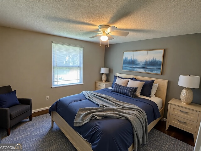 bedroom featuring a textured ceiling, ceiling fan, dark wood-style floors, and baseboards