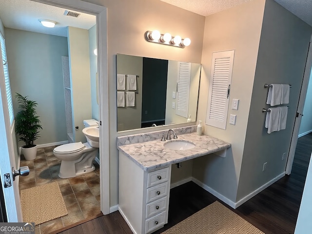 full bath with toilet, a textured ceiling, baseboards, wood finished floors, and visible vents