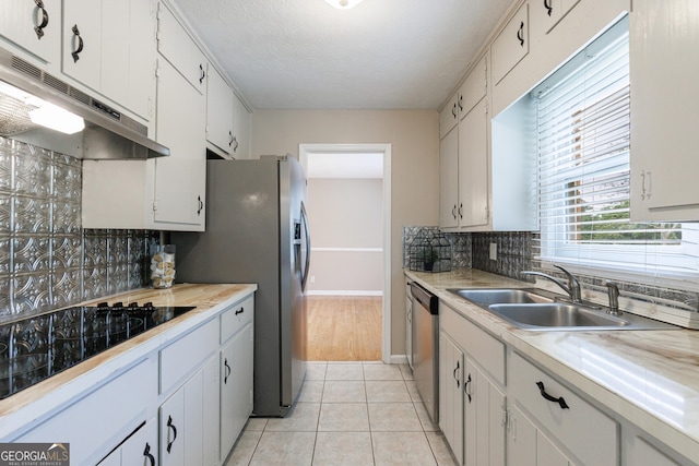 kitchen with a sink, decorative backsplash, under cabinet range hood, and dishwasher