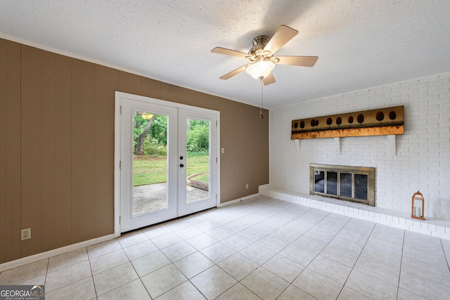 unfurnished living room with a textured ceiling, french doors, tile patterned flooring, and a fireplace