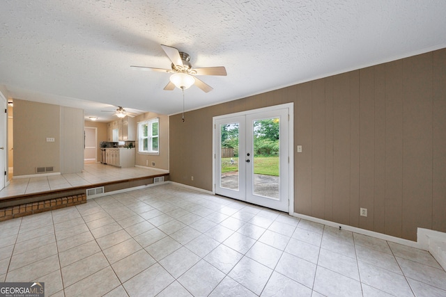 unfurnished living room with french doors, ceiling fan, visible vents, and baseboards