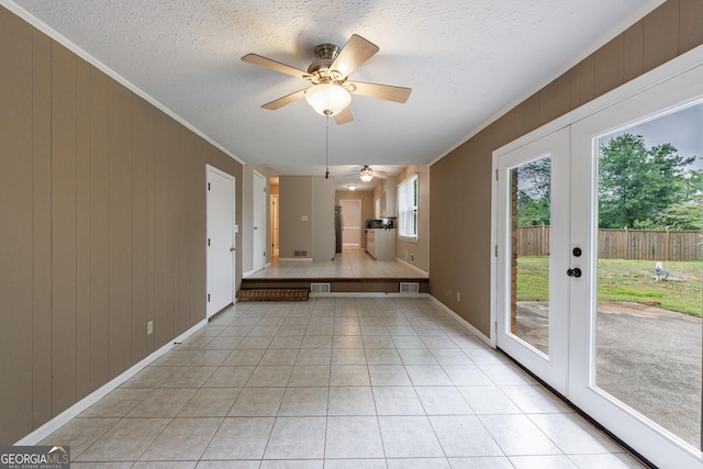 unfurnished dining area featuring crown molding, french doors, baseboards, light tile patterned floors, and visible vents