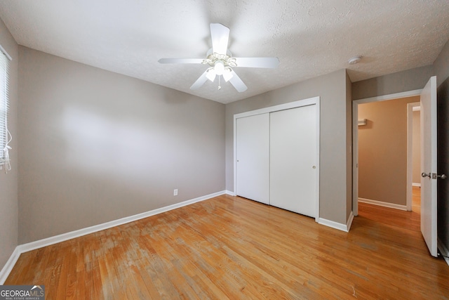 unfurnished bedroom with a closet, baseboards, ceiling fan, and light wood-type flooring