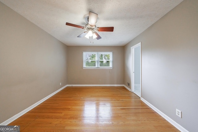 unfurnished room featuring baseboards, a ceiling fan, a textured ceiling, and light wood-style flooring