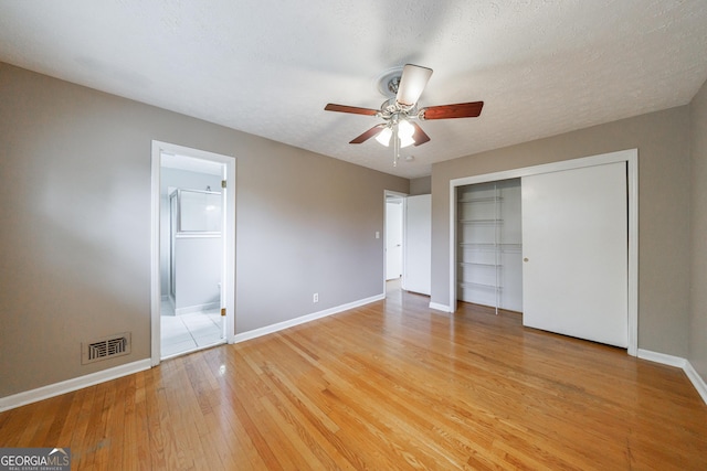 unfurnished bedroom with visible vents, a closet, baseboards, ensuite bathroom, and light wood-style flooring