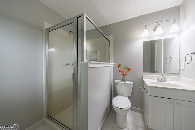 bathroom with vanity, toilet, tile patterned floors, baseboards, and a stall shower