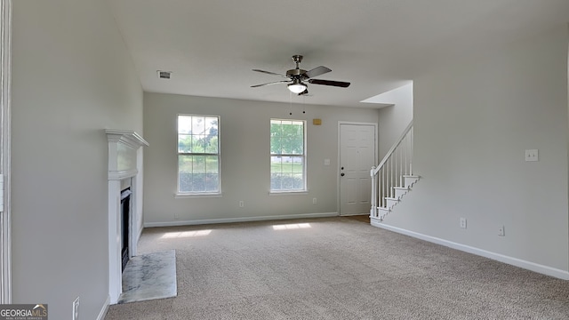 64 Dogwood Rdg, Hampton, GA 30228 - unfurnished living room with carpet floors, a ceiling fan, baseboards, a fireplace with flush hearth, and stairway