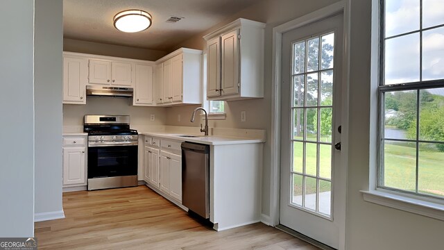 64 Dogwood Rdg, Hampton, GA 30228 - kitchen with appliances with stainless steel finishes, a sink, light wood finished floors, light countertops, and under cabinet range hood