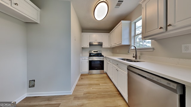 64 Dogwood Rdg, Hampton, GA 30228 - kitchen with visible vents, a sink, under cabinet range hood, stainless steel appliances, and light wood-style flooring