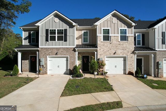 townhome / multi-family property featuring board and batten siding, brick siding, an attached garage, and concrete driveway