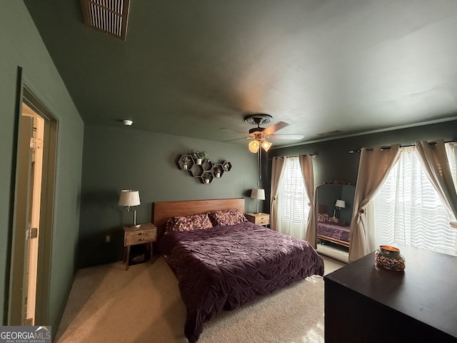 carpeted bedroom featuring ceiling fan and visible vents