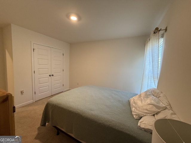 carpeted bedroom with baseboards and a closet