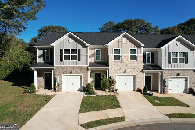 townhome / multi-family property featuring a garage, board and batten siding, and driveway