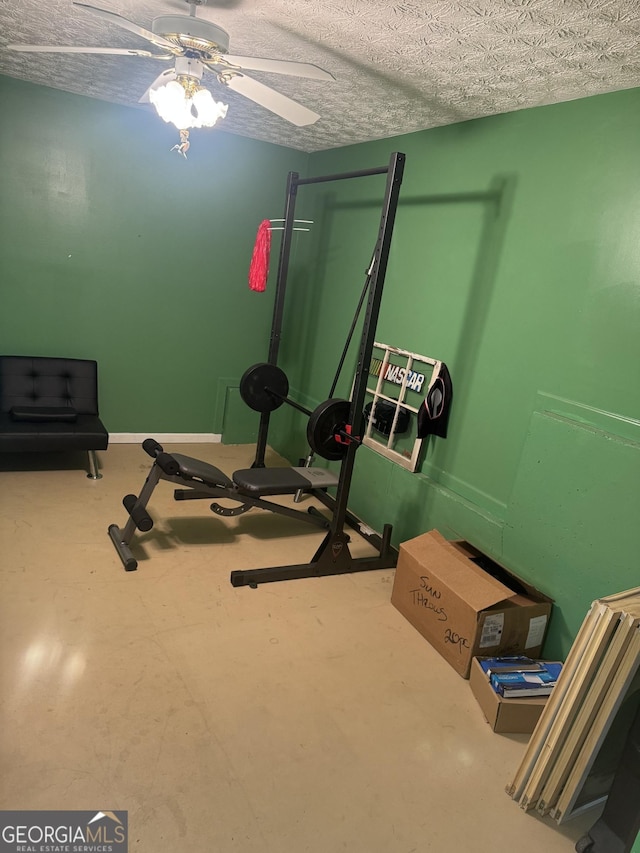 exercise area with a textured ceiling and ceiling fan