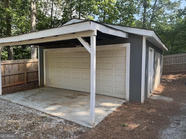 detached garage featuring fence