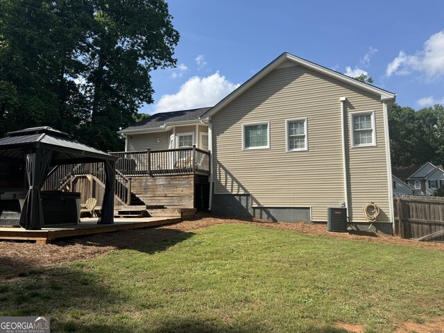 back of house with a lawn, fence, a wooden deck, and a gazebo