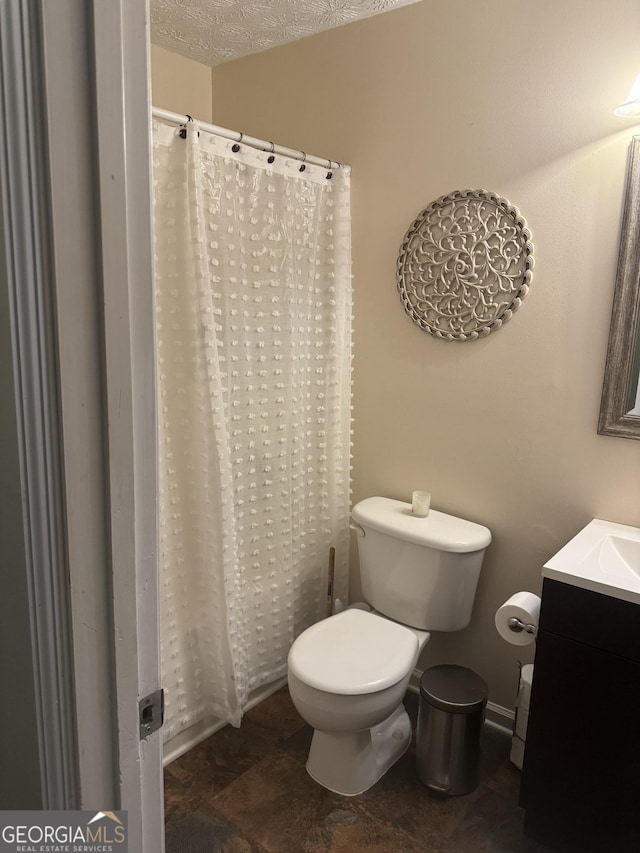 bathroom with toilet, curtained shower, and vanity