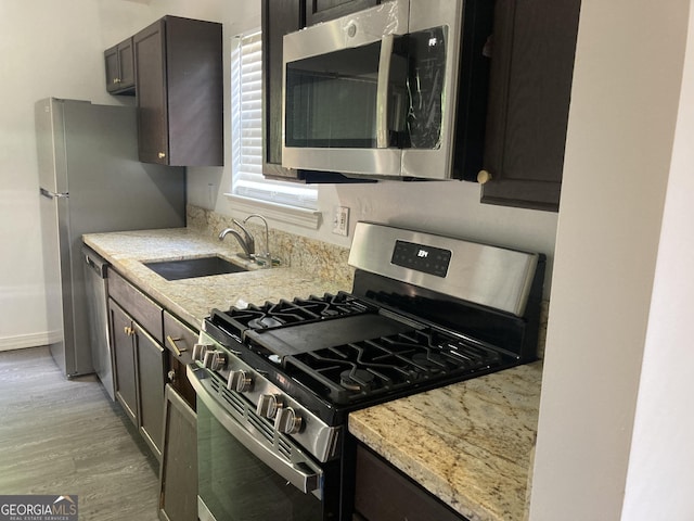 1047 Plantation Way NW, Kennesaw, GA 30144 - kitchen with stainless steel appliances, a sink, light stone counters, and light wood-style floors