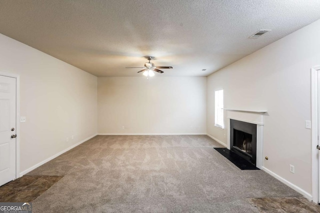 unfurnished living room featuring a fireplace with flush hearth, baseboards, ceiling fan, and carpet flooring