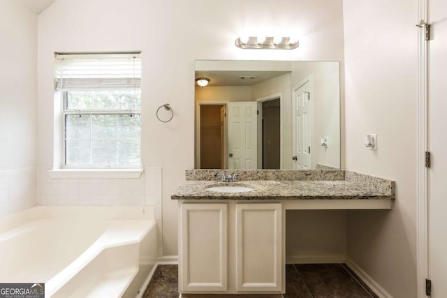 full bathroom with baseboards, tile patterned floors, a bath, and vanity
