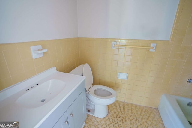 full bath with toilet, tile walls, a bath, and vanity