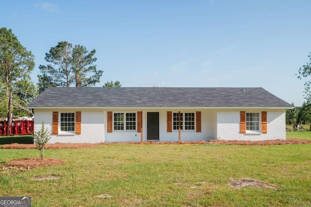 ranch-style house featuring brick siding and a front lawn