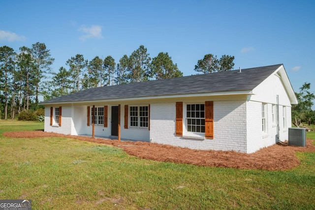 single story home featuring brick siding, central AC unit, a front lawn, and a porch